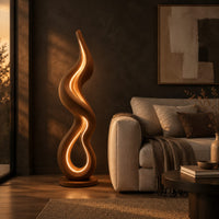 Flame shaped wooden floor lamp with a glowing loop on a disc base in a dark living room at golden hour