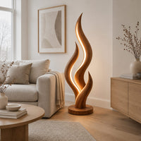 Flame shaped floor lamp with layered tongues and a glowing seam in a Scandinavian living room with white walls