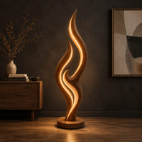 Tall flame shaped floor lamp with layered wooden ribbons on a disc base in a dark studio against a charcoal plaster wall