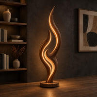 Tall flame shaped floor lamp with layered wooden ribbons on a disc base, three-quarter view showing the grain