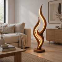 Tall flame shaped floor lamp with layered wooden ribbons on a disc base in a Scandinavian living room with white walls