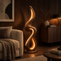 Flame shaped floor lamp with a looping wooden ribbon and glowing inner edge in an evening living room with walnut wall paneling
