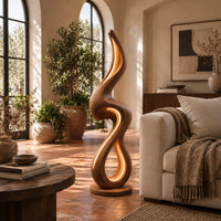 Flame shaped floor lamp with a looping wooden ribbon and glowing inner edge in a bright living room with arched windows and plants