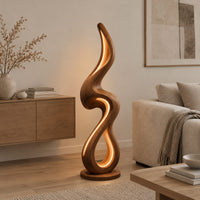Flame shaped floor lamp with a looping wooden ribbon and glowing inner edge in a Scandinavian living room with white walls