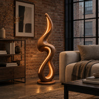 Flame shaped floor lamp with a looping wooden ribbon and glowing inner edge in an industrial loft living room with exposed brick