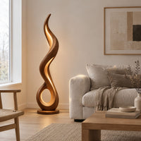 Flame shaped floor lamp with an open loop base and inner glow in a Scandinavian living room with white walls