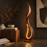 Corner detail of flame shaped floor lamp with an open teardrop loop and a glowing edge beside wood, brass and linen samples