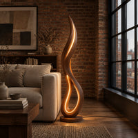 Flame shaped floor lamp with an open teardrop loop and a glowing edge in an industrial loft living room with exposed brick