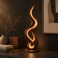 Corner detail of flame shaped wooden lamp with open loops and a glowing edge line beside wood, brass and linen samples