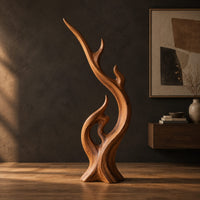 Flame shaped wood sculpture with a long sweeping arm and an open loop in a dark studio against a charcoal plaster wall