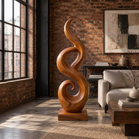 Flowing flame sculpture with a spiral scroll at its foot and a block base in an industrial loft living room with exposed brick
