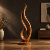Flame shaped wood sculpture with an open loop on a disc base in a dark studio against a charcoal plaster wall