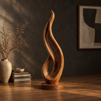 Flame shaped wood sculpture with an open loop on a disc base, three-quarter view showing the grain