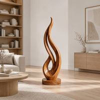 Flame shaped wood sculpture with an open loop on a disc base in a Scandinavian living room with white walls