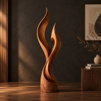Wood sculpture shaped like two rising flames with smooth swept lines, three-quarter view showing the grain
