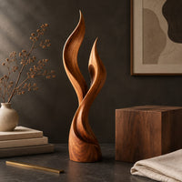 Corner detail of wood sculpture shaped like two rising flames with smooth swept lines beside wood, brass and linen samples