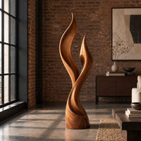 Wood sculpture shaped like two rising flames with smooth swept lines in an industrial loft living room with exposed brick