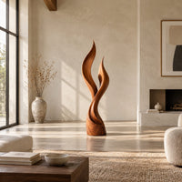 Wood sculpture shaped like two rising flames with smooth swept lines in a bright open plan living room
