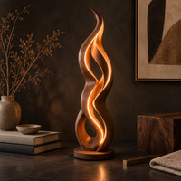 Corner detail of floor lamp shaped like a twisting flame on a flat disc base beside wood, brass and linen samples