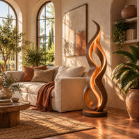 Floor lamp shaped like a twisting flame on a flat disc base in a bright living room with arched windows and plants