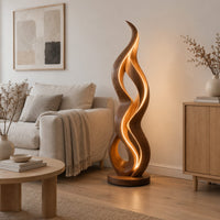 Floor lamp shaped like a twisting flame on a flat disc base in a Scandinavian living room with white walls