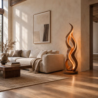 Floor lamp shaped like a twisting flame on a flat disc base in a bright open plan living room
