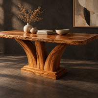 Corner detail of rectangular dining table with two flared pedestal legs on a stepped plinth beside wood, brass and linen samples