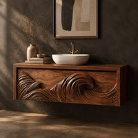 Floating bathroom vanity with a carved ocean wave on two front panels, three-quarter view showing the grain
