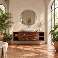 Floating bathroom vanity with carved wave doors and open end shelves in a bright bathroom with arched windows and plants