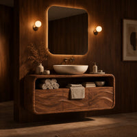 Floating vanity cabinet with carved wave fronts and an open top niche in an evening bathroom with walnut wall paneling