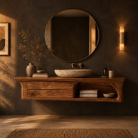 Floating wooden vanity cabinet with flared ends and an open shelf in a dark bathroom at golden hour