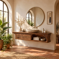 Floating wooden vanity cabinet with flared ends and an open shelf in a bright bathroom with arched windows and plants