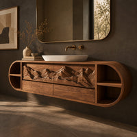 Corner detail of pill shaped floating cabinet with carved mountain front and open end cubbies beside wood, brass and linen samples