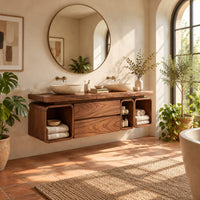 Floating wooden bathroom vanity cabinet with open cubbies and a thick top in a bright bathroom with arched windows and plants