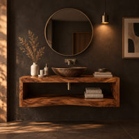 Floating wooden bathroom vanity with a slab top and an open shelf below in a dark bathroom at golden hour