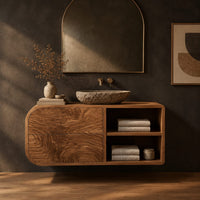 Floating bathroom vanity with rippled drawers and open shelves in a dark studio against a charcoal plaster wall
