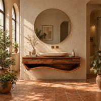 Floating wood vanity cabinet with a sweeping wave shaped open shelf underneath in a bright bathroom with arched windows and plants