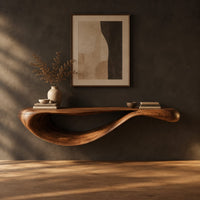 Floating console table with a sweeping wave shaped underside in a dark studio against a charcoal plaster wall
