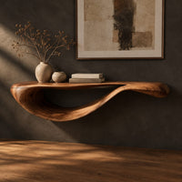 Corner detail of floating console table with a sweeping wave shaped underside beside wood, brass and linen samples