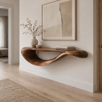 Floating console table with a sweeping wave shaped underside in a Scandinavian entryway with white walls