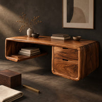 Corner detail of floating desk with a soft edged body, open cubby shelf and two drawers beside wood, brass and linen samples