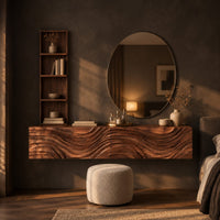 Floating makeup vanity with a carved wave front and a tall open shelf in a dark bedroom at golden hour