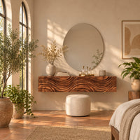 Floating makeup vanity with a carved wave front and a tall open shelf in a bright bedroom with arched windows and plants
