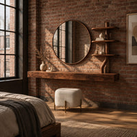 Floating wood makeup vanity with a circular mirror and a branch shaped tiered shelf in an industrial loft bedroom with exposed brick
