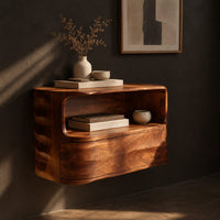 Floating nightstand with a curved open shelf and wavy carved sides, three-quarter view showing the grain