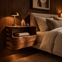 Floating nightstand with a curved open shelf and wavy carved sides in an evening bedroom with walnut wall paneling