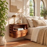 Floating nightstand with a curved open shelf and wavy carved sides in a bright bedroom with arched windows and plants