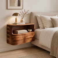 Floating nightstand with a curved open shelf and wavy carved sides in a Scandinavian bedroom with white walls