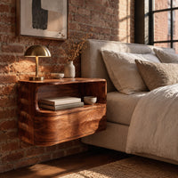 Floating nightstand with a curved open shelf and wavy carved sides in an industrial loft bedroom with exposed brick