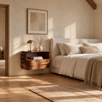 Floating nightstand with a curved open shelf and wavy carved sides in a bright open plan bedroom